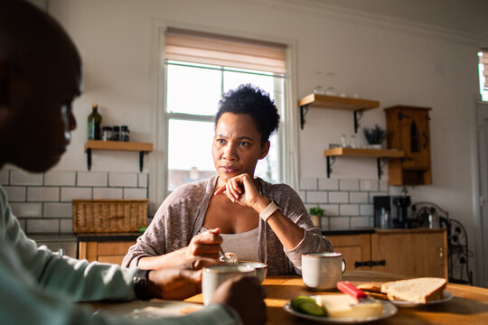 Serious couple conversation over morning coffee in home kitchen