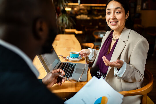 Business professionals discussing analytics over coffee in a cafe