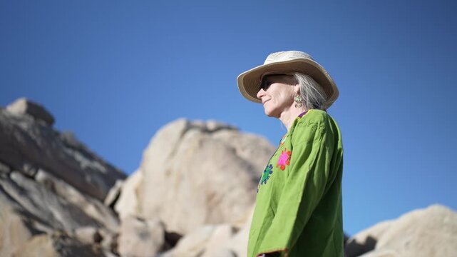 Mature woman enjoys a sunset hike in Joshua Tree National Park, exploring the desert trails and appreciating the surroundings.