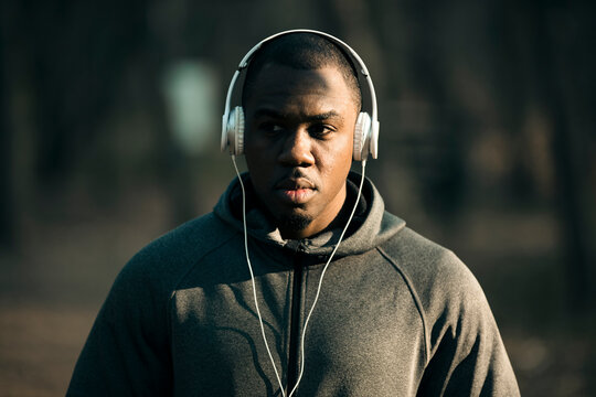 Focused runner with headphones on park trail