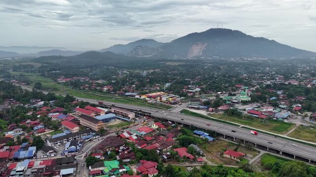 Aerial drone view of Kubang Semang town with highway and hills