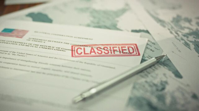 A red secrecy stamp on confidential USA documents lies on a desk, adjacent to a USA flag and a detailed world map, with a pen, showcasing the handling of sensitive information in an official setting