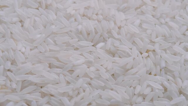 Close-up rotating video of white rice grains. footage highlights purity, simplicity, natural food texture. Ideal for culinary projects, food advertising, healthy eating concepts, packaging visuals