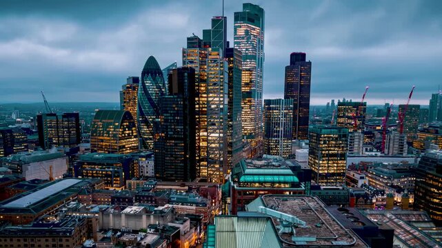 Aerial hyperlapse view of the City of London skyline during dusk with fast moving clouds