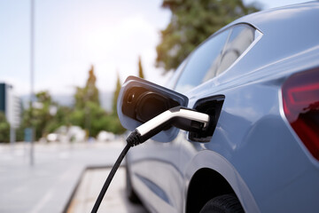 Charging an electric car in a sunny urban setting