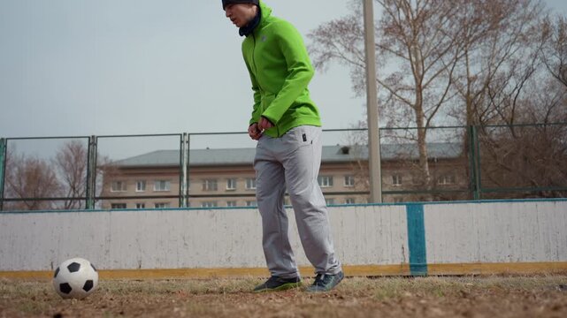 white male practicing soccer with precision, controlled closeup of man passing soccer ball skillfully, autumnlit scene with male soccer player emphasizing accurate touch and control