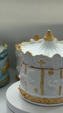 Rotating plaster candle holder in the shape of a carousel with a burning candle, an elegant decorative element for luxurious interiors and festive concepts