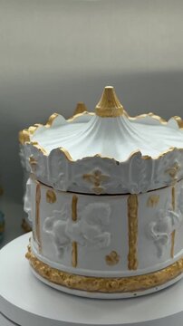 Rotating plaster candle holder in the shape of a carousel with a burning candle, an elegant decorative element for luxurious interiors and festive concepts