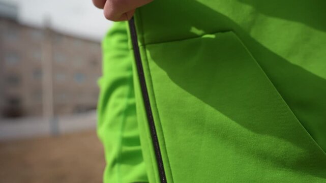 focused hands enhancing athletic jacket fit, detailed view of hands preparing sportswear before game, close examination of hands customizing sports jacket in energetic pregame setting