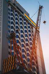 Construction crane by modern building facade at urban real estate development, Lifting tower by high rise architecture, property construction growth
