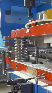 Witness the mesmerizing rhythm of an automated sheet metal stamping machine in an industrial factory.