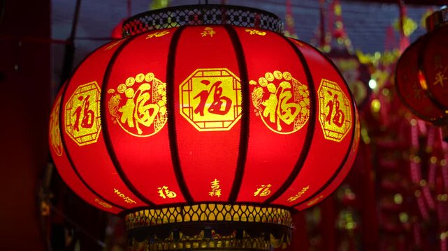 lanterns with Chinese blessing "Fu" on hanging for Chinese new year in a chinatown at night. word Translation:good luck for new year