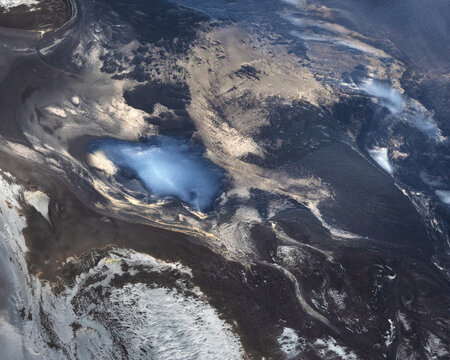 Aerial view of a glacial lake, its startling turquoise waters juxtaposed against the stark, volcanic landscape, a mesmerizing display of nature's artistry, Reykjavik, Iceland.