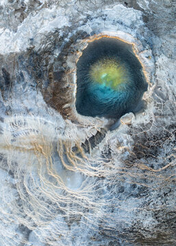 Aerial view of an otherworldly geothermal spring, its turquoise heart ringed by mineral deposits and filamentous algae, a stark beauty unfolds, Reykjavik, Iceland.