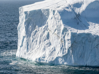 Large rugged iceberg with uneven icy surface in sea water