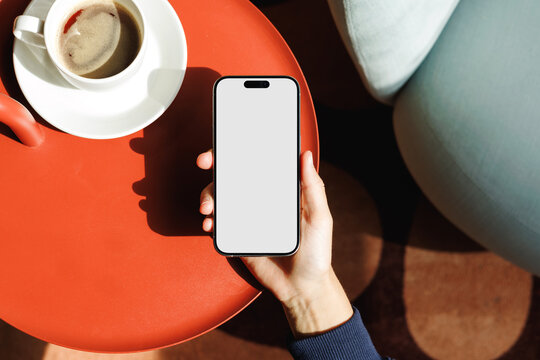 Hand Holding Smartphone Mockup Beside Coffee Cup