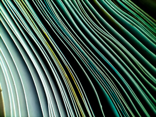 Fototapeta premium Close-up of stacked paper sheets viewed from the edge, highlighting their layered texture and wavy alignment. 