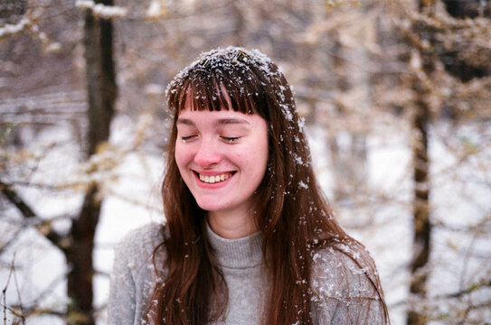 Smiling Girl in a Snowy Forest During Winter Time