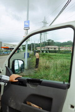 Man urinating by the roadside near an industrial area