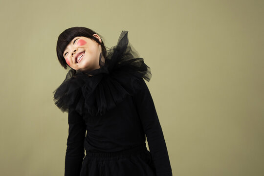 Young girl in black costume with tulle collar smiles for the camera