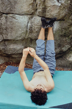 Climber lying down problem solving a boulder 