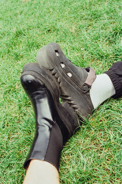 Detail of a couple feet wearing black shoes of different styles