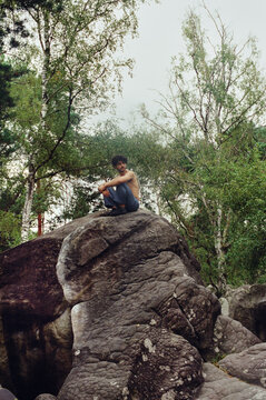 Man sitting in the top of a rock wall at Fountaineblueau