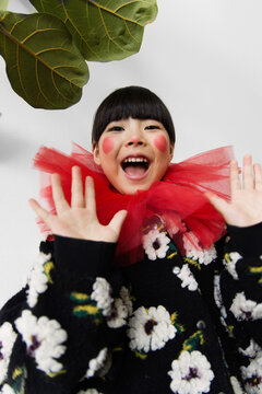 Joyful  girl with a red ruff and floral sweater expressing happiness