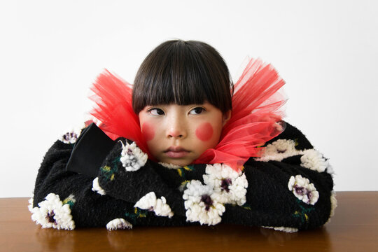 Young girl with a playful expression wearing colorful clothing