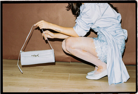 Close view of woman holding blue handbag