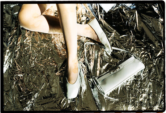 Blue shoes and handbag on reflective metallic surface