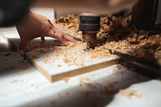 Hand Guiding Wood Under Drill Press