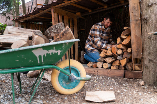 Man Stacking Firewood Logs