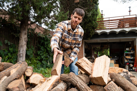 Man Carrying Firewood Logs