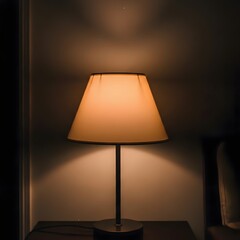 A warm and cozy table lamp with a soft glowing light shade in a dark room setting