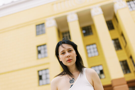 Young Woman Posing in Front of a Yellow Historic Building
