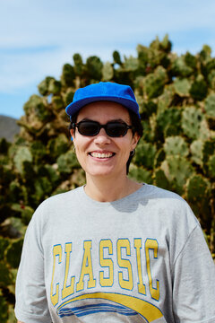 Portrait of a woman wearing sunglasses and a blue cap