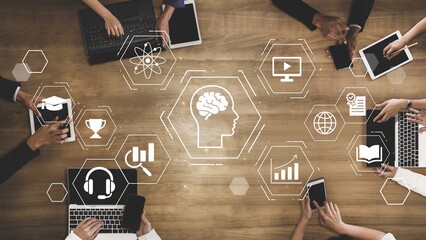 Diverse Hands Engaging with Technology and Innovation Symbols Over a Wooden Table Representing...