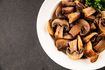 Fototapeta premium Champignon mushrooms ready to eat tasty snack fresh gourmet food background on the table rustic food top view copy space keto and paleo diet vegetarian and vegan food marketing concept photo