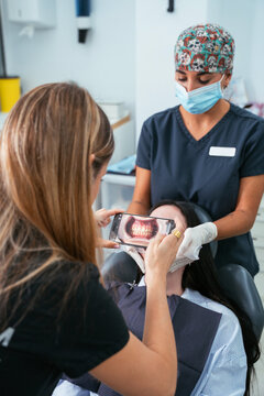 Dentist performing dental examination with digital technology