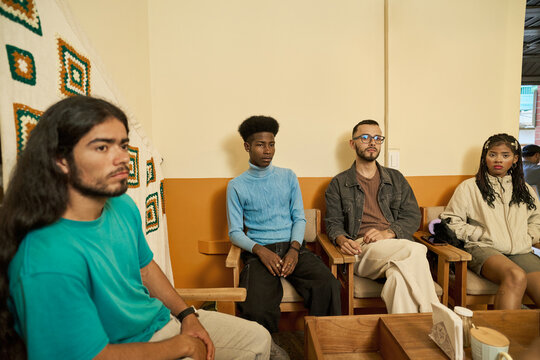 Diverse young friends sitting in cafe listening