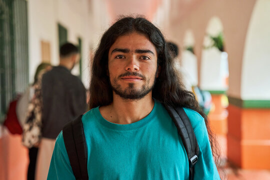 Hispanic male student standing in university hallway