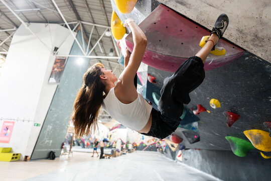 Woman bouldering in climbing gym mastering challenges