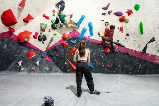People bouldering on artificial rock climbing wall in gym
