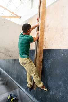 Man training on campus board improving climbing strength