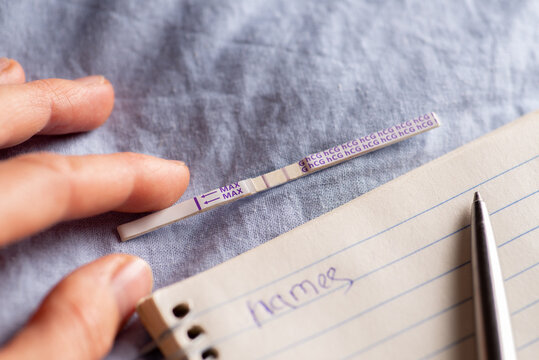 Positive pregnancy test and notebook with pen