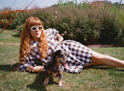 Woman Relaxing Outdoors With Dog in a Sunny Garden