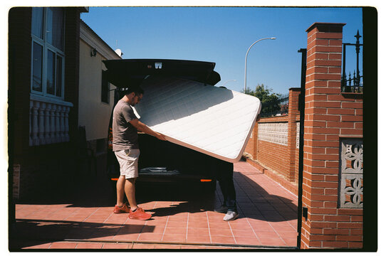 Men Carrying Mattress Outdoors
