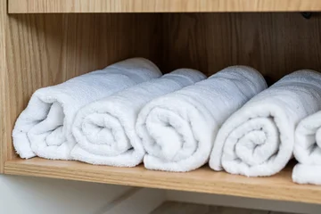 Minimalist Bathroom Interior with White Towels rolled up on shelf © Rhonda
