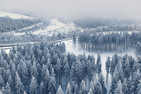 Aerial view of snow-laden conifers and frosted landscapes create a serene winter wonderland, Winterberg, North Rhine-Westphalia, Germany.